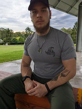 Grey undershirt worn by a defence member with tattos and a norse necklace